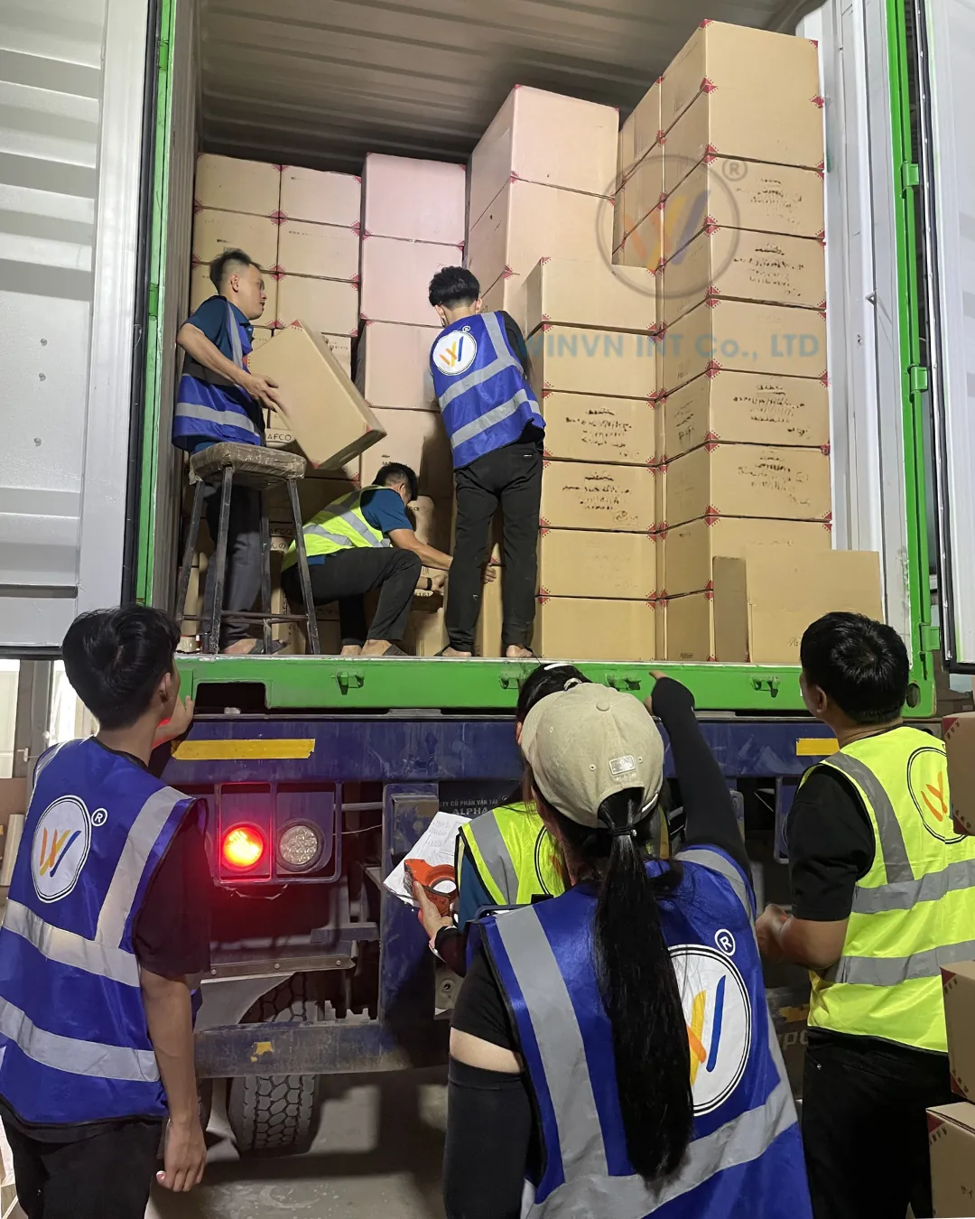 Warehouse team loading cartons of loofah products into a shipping container in Vietnam